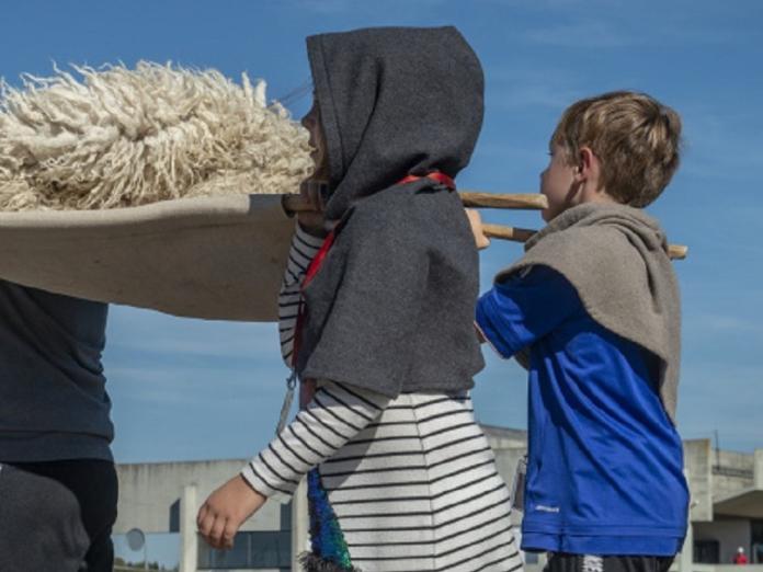 Børn bærer skind til skibet