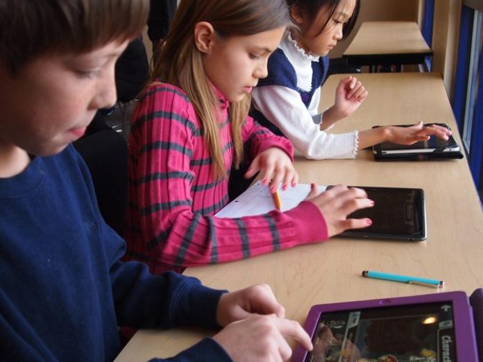 Elever i en klasse, der kigger på ipads.