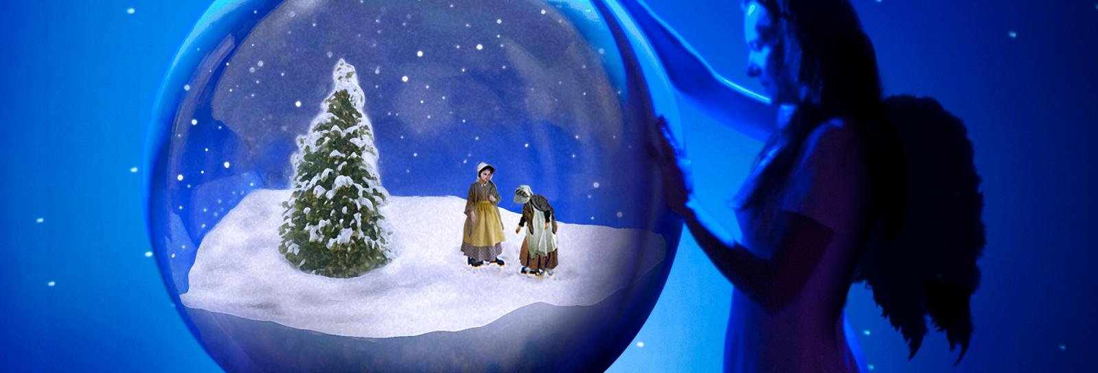 Stor julekule med to børn og et grantræ og en engel der står udenfor julekulen og passer på dem