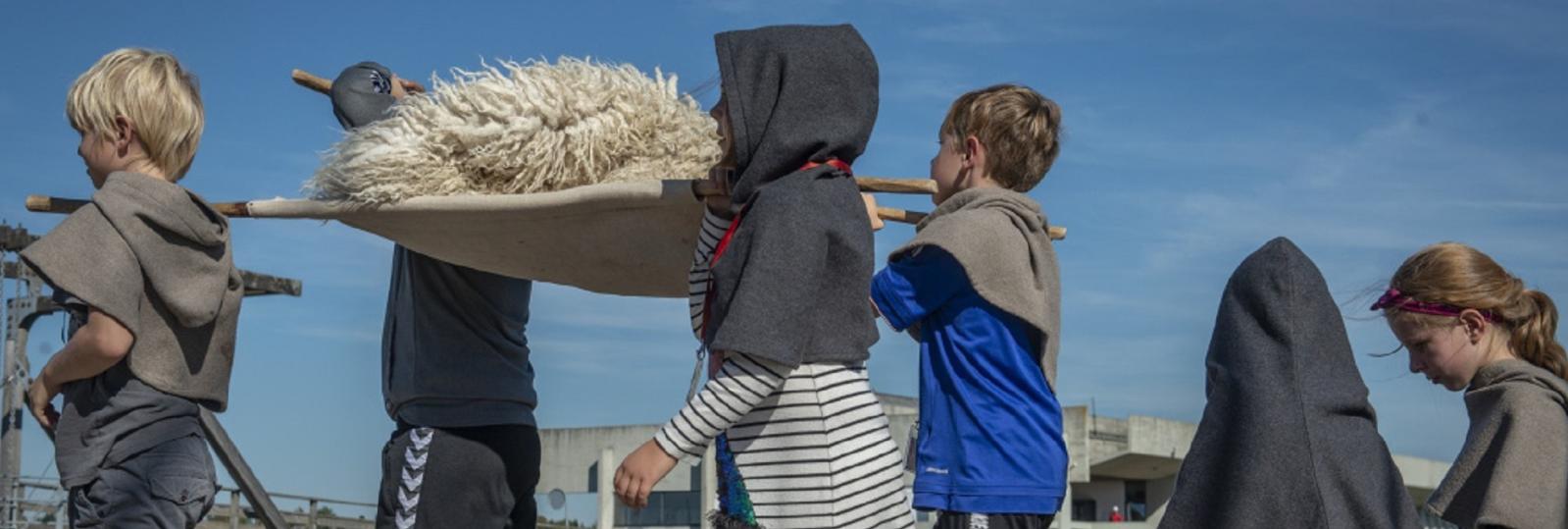 Børn bærer skind til skibet