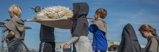 Børn bærer skind til skibet